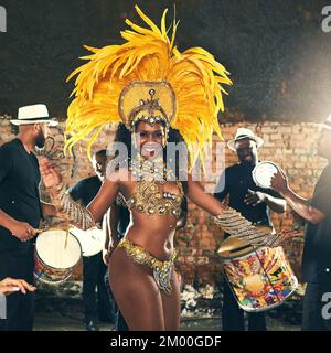 Samba, danza e donna nera a Carnevale per celebrare, energia notturna e festa di vacanza a Rio de Janeiro, Brasile. Street band, musica sorriso e ritratto Foto Stock