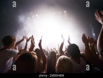 Concerto, musica dal vivo e persone che ballano in un evento, una festa o un night club con energia, libertà e divertimento. Band, musicista o dj intrattenimento in esecuzione Foto Stock