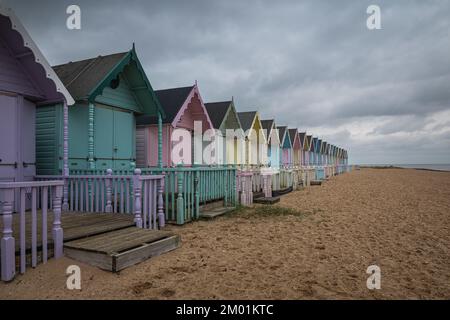 Capanne sulla spiaggia di Mersea Island in Essex. Moody, cielo nuvoloso e foto a lunga esposizione. Foto Stock