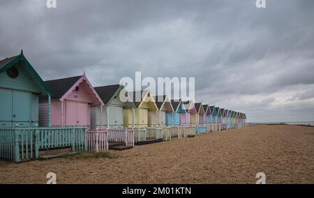 Capanne sulla spiaggia di Mersea Island in Essex. Moody, cielo nuvoloso e foto a lunga esposizione. Foto Stock