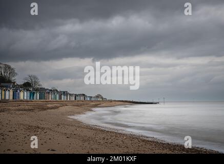 Capanne sulla spiaggia di Mersea Island in Essex. Moody, cielo nuvoloso e foto a lunga esposizione. Foto Stock