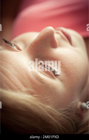 ritratto di una giovane donna bionda pensiva Foto Stock