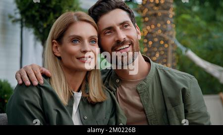 Coppia sposata amorevole marito e moglie uomo caucasico bearded e donna bionda 40s sposi sedersi all'aperto guardando in distanza sognando contemplare Foto Stock