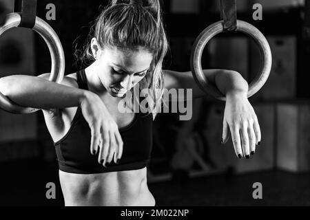 Donna cross training utilizzando anelli Foto Stock