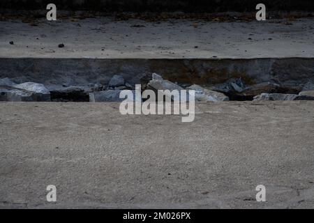 Macerie di cemento in un fossato in un cantiere Foto Stock