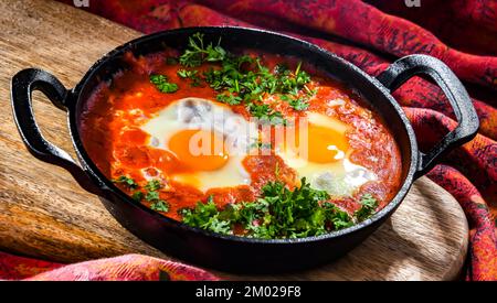 Piatto shakshouka in una padella di ghisa. Foto Stock