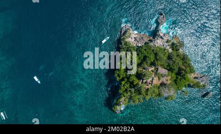 Vista aerea della bellissima isola rocciosa verde nell'oceano blu. Foto Stock