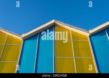 Lato di un edificio blu e giallo contro un cielo blu. Edificio colorato Foto Stock