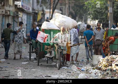 Dhaka, Bangladesh. 3rd Dec, 2022. Dopo la raccolta di rifiuti da luoghi diversi, una persona sta portando in un furgone per scaricarlo nella discarica di rifiuti sulle rive del fiume Buriganga, a Dhaka, Bangladesh, 3 dicembre 2022. Le persone coinvolte nella raccolta e nel trasporto di questi rifiuti non rispettano le norme igieniche. Credit: ZUMA Press, Inc./Alamy Live News Foto Stock