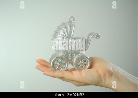 Nascita di un bambino invito a battesimo o riunione da palmo di ospedale di una donna si trova Silver baby carrozza albero di Natale giocattolo Foto Stock