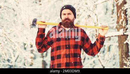 Lumberjack nel bosco con un'ascia. Woodman che lavora nella foresta. Bell'uomo, hipster, lumberjack, ascia. Brutale uomo bearded con barba, baffi su Foto Stock