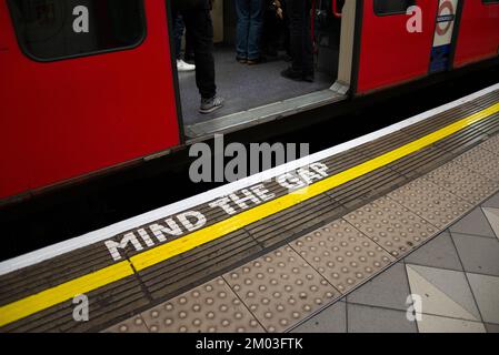 Attenzione al cartello GAP, sulla metropolitana di Londra. Segnale di avvertimento sul bordo della piattaforma presso la stazione Bank sulla Central Line. Ampio spazio tra la piattaforma e la porta del treno Foto Stock