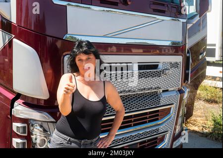 Il conducente di un carrello mostra i pollici verso l'alto Foto Stock