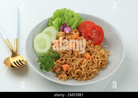 Indomie Goreng popolare indonesiano Instant Noodle su tavolo bianco Foto Stock