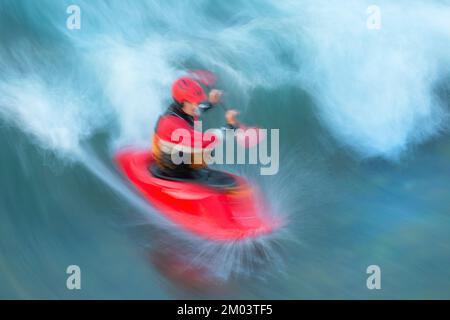 Kayak di acqua bianca che attraversa l'onda sul fiume Bow a Calgary, Alberta, Canada. Sfocatura del movimento. Foto Stock