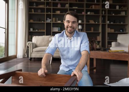 Buon compratore di mobilia che monta il pezzo di legno nel paese Foto Stock