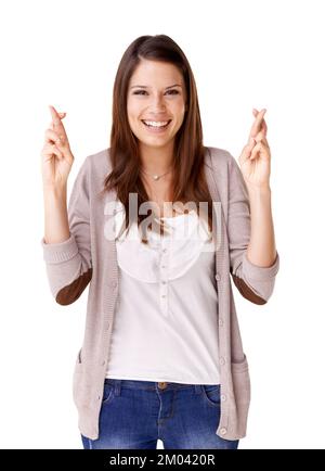 Sentirsi fortunati. Giovane donna sorridente con le dita incrociate su uno sfondo bianco. Foto Stock