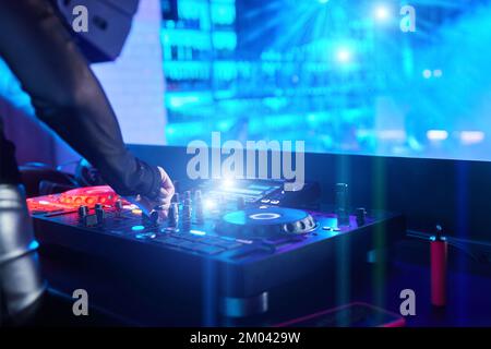 DJ ragazza che suona musica con giradischi e mixer sul palco nel night club Foto Stock