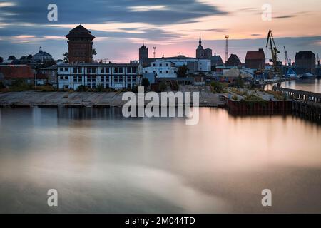 Edifici portuali, gru da cantiere e torri di chiese, skyline al tramonto, esposizione lunga, porto di Stralsund, Germania, Europa Foto Stock