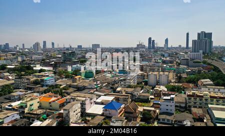 Vista dal piano alto delle strade di Bangkok. Edifici alti e tetti di piccole case. Paesaggio della città Foto Stock