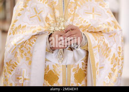 La selezione centrale del sacerdote tiene una croce nelle sue mani Foto Stock