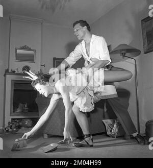 Ballerina negli anni '1950s. Una giovane ballerina tutta vestita con il suo costume e le sue scarpe sta pulendo il pavimento insieme al marito. I loro nomi sono Kerstin Bratt Deckner e John-Ivar Deckner, ballerini e attori teatrali. Svezia 1953 Kristoffersson Rif. BK4-12. Foto Stock