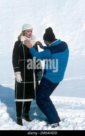 La moda negli anni '1980s. Un giovane modello è in fase di preparazione per una foto. Indossa la moda invernale degli anni, un cappotto caldo. Viene visualizzato un assistente che completa i dettagli. Svezia marzo 1980 Foto Stock