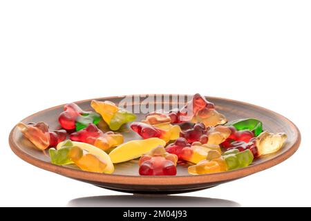 Diversi orsacchiotti di gelatina su un piatto di argilla, macro, isolato su uno sfondo bianco. Foto Stock