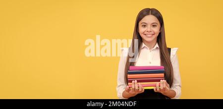 ragazza teen felice nella pila uniforme del libro della presa della scuola, lettura. Banner della studentessa scolastica. Ritratto della studentessa con spazio per la copia. Foto Stock