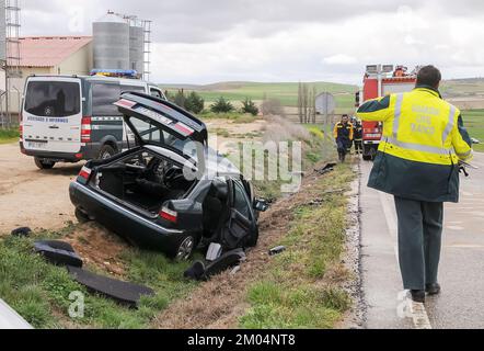 Veicolo fuori strada dopo un incidente stradale con un poliziotto della guardia civile che cammina sulla strada. Foto Stock