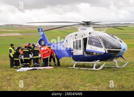 Elicottero in attesa di essere caricato con una persona ferita da un incidente stradale da paramedici e vigili del fuoco. Foto Stock