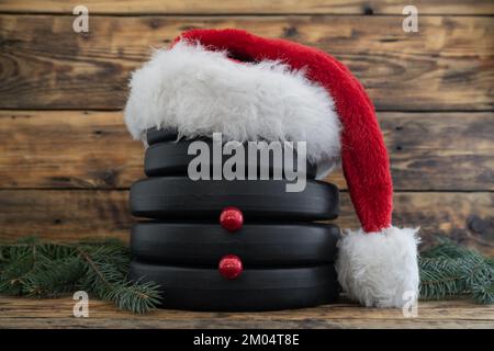 Piatti pesi a manubri a forma di pupazzo di neve, con cappello rosso di Natale di Babbo Natale. Composizione fitness sana. Allenamento in palestra. Foto Stock
