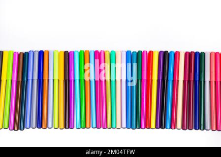 Un set di penne multicolore in fila, arcobaleno su uno sfondo bianco chiaro per striscioni. Tracciatura di marcatori, matite, inchiostro, strumenti per artisti, creat Foto Stock