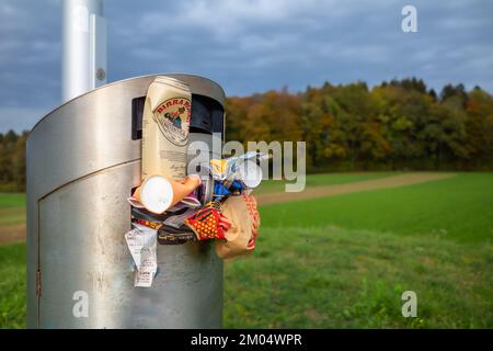 Embrach, Svizzera - 23 ottobre 2022: Un cestino pieno su una piattaforma di osservazione ai margini di una foresta autunnale Foto Stock