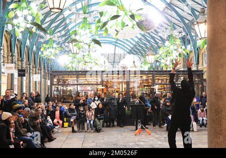 Busker a Covent Garden molto impegnato nella stagione natalizia, 2022, nonostante il costo della crisi, nel centro di Londra, nel Regno Unito Foto Stock