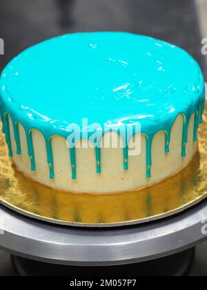 guarnizione per il riempimento del sacchetto su una torta di colore turchese glassa glassa glassa glassa glassa glassa per festeggiare il compleanno Foto Stock