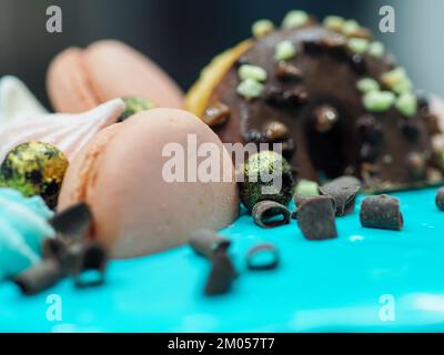 donuts meringa bacche e brillantezza guarnizione su glassa glassa glassa torta turchese gocciolamento per la celebrazione del compleanno Foto Stock