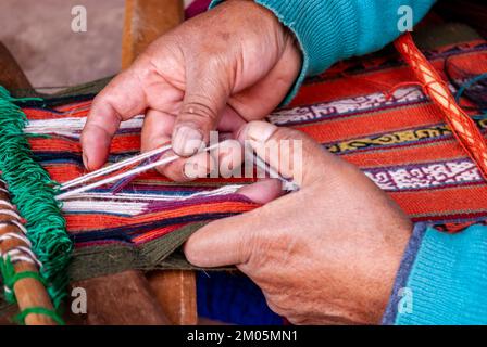 Primo piano di tessitura tessile utilizzando telaio manuale in Perù Foto Stock