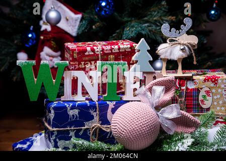 alce a maglia. alce carina. Giocattolo sullo sfondo di una ghirlanda di Capodanno, lepre e alce a maglia su un albero di Natale con regali Foto Stock