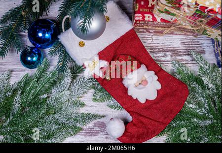 Composizione a posa piatta con streamers a serpentina e decorazioni natalizie su sfondo in legno. Spazio per il testo Balls, Branches, Hat, Presents Foto Stock