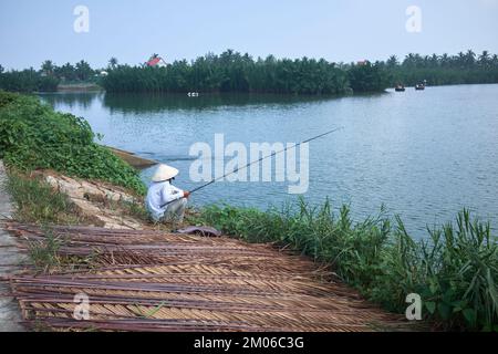 Pescatore in coolie cappello sulle zone umide a Hoi An Vietnam Foto Stock