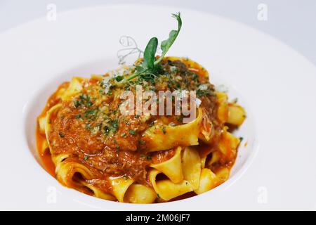 pasta italiana con ragù di manzo tritato noto come salsa bolognese nel piatto di servizio Foto Stock