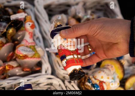 Un giocattolo dell'albero di Natale sotto forma di Nutcracker si trova sul banco tra i giocattoli dell'albero di Natale durante il Capodanno e le vacanze di Natale a Mosca, Russia Foto Stock