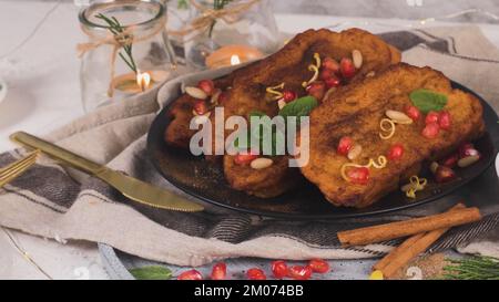 Rabanadas di Natale tradizionale con semi di pommegranate, pinoli e cannella. Torrijas spagnolo o toast francesi vicino sul banco. Foto Stock