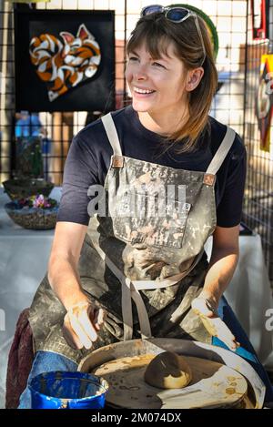 Allegra artista di ceramica prepara argilla su una ruota di ceramica per una dimostrazione alla fiera d'arte di Tucson, Arizona Foto Stock