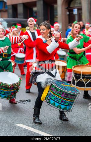 Liverpool, Regno Unito. 04th Dec, 2022. I batteristi Batala Mersey Samba Reggae offrono intrattenimento per la folla e per stimolare i corridori lungo il percorso del Liverpool Santa Dash. Migliaia di corridori si portano per le strade di Liverpool vestito come Babbo Natale in abiti Santa rossi e blu durante il BTR Liverpool Santa Dash 2022, una raccolta di fondi del 5k per beneficenza tra cui l'Alder Hey Children's Hospital. Credit: SOPA Images Limited/Alamy Live News Foto Stock