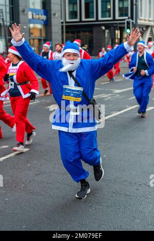 Liverpool, Regno Unito. 04th Dec, 2022. Un corridore alza le braccia mentre prende parte all'annuale Liverpool Santa Dash. Migliaia di corridori si portano per le strade di Liverpool vestito come Babbo Natale in abiti Santa rossi e blu durante il BTR Liverpool Santa Dash 2022, una raccolta di fondi del 5k per beneficenza tra cui l'Alder Hey Children's Hospital. Credit: SOPA Images Limited/Alamy Live News Foto Stock