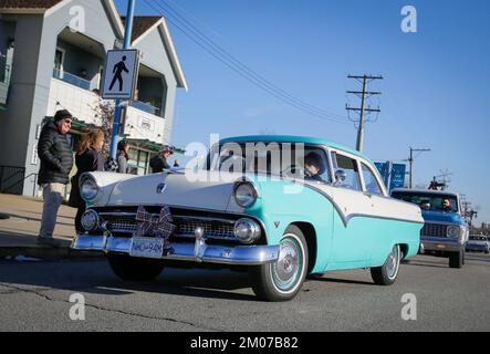 Richmond, Canada. 4th Dec, 2022. La gente guarda le auto classiche che navigano su una strada durante l'annuale evento Christmas Classic Car Cruise a Richmond, British Columbia, Canada, il 4 dicembre 2022. Credit: Liang Sen/Xinhua/Alamy Live News Foto Stock