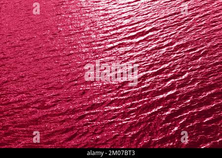 Viva Magenta tessuto di acqua di mare tonico. Acqua di piscina con riflessi di sole. Colore trendy 2023 anno. Foto Stock