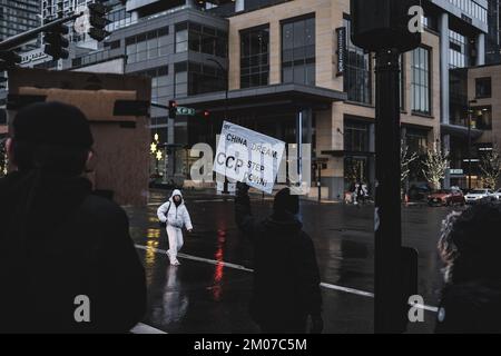 Bellevue, Stati Uniti. 04th Dec, 2022. Un protester tiene un cartello durante la dimostrazione. I manifestanti hanno tenuto un rally sotto la forte pioggia in solidarietà con il popolo Urumqi a Bellevue, Seattle. In Cina, il "Libro bianco" era noto come la "Rivoluzione del A4". Nel Bellevue Downtown Park, una ventina di manifestanti si sono riuniti per manifestare contro la politica cinese di 'zero-covid' e per pregare per le vittime del tragico incendio di Urumqi. Credit: SOPA Images Limited/Alamy Live News Foto Stock